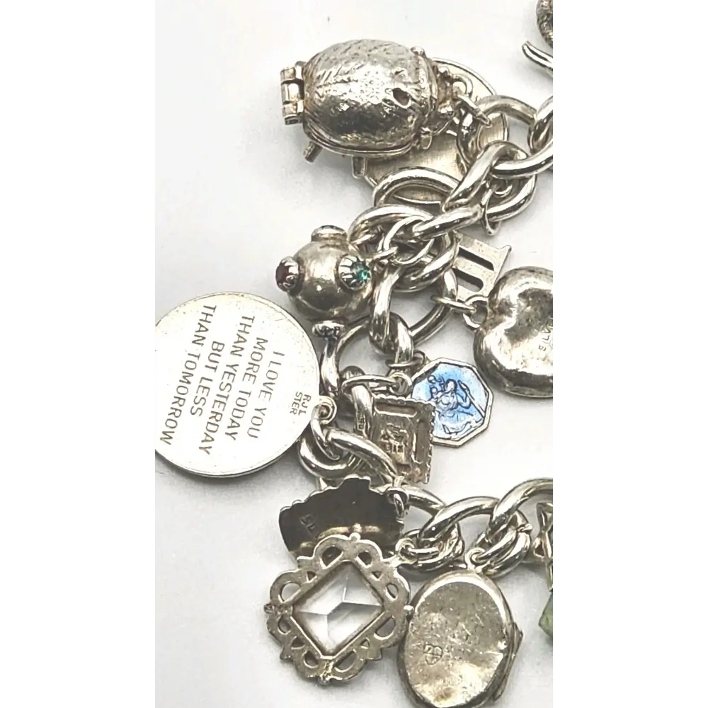 Silver charm bracelet with various charms on a white background