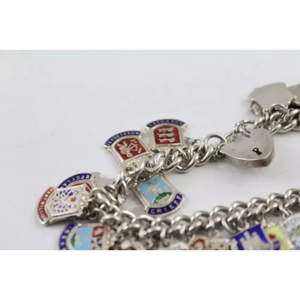 Silver bracelet with various charms on a light gray background