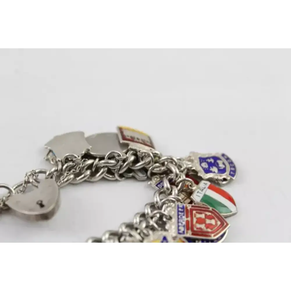 Silver charm bracelet with various charms on a white background