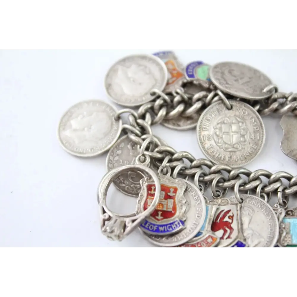 Silver charm bracelet with various charms on a white background