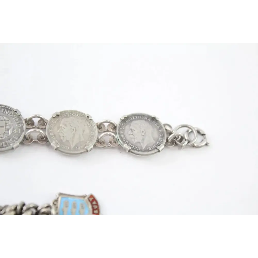 Silver bracelet with coin charms on a white background