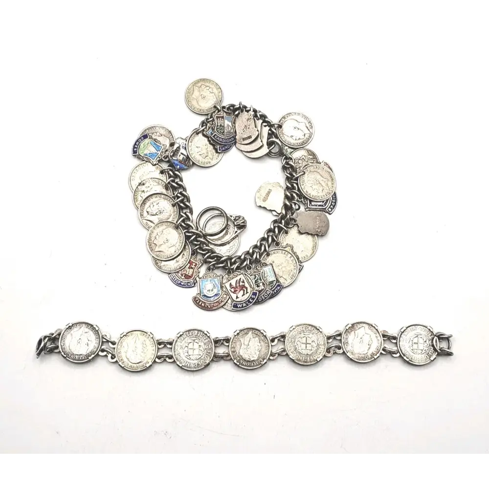 Silver charm bracelet with various charms on a white background