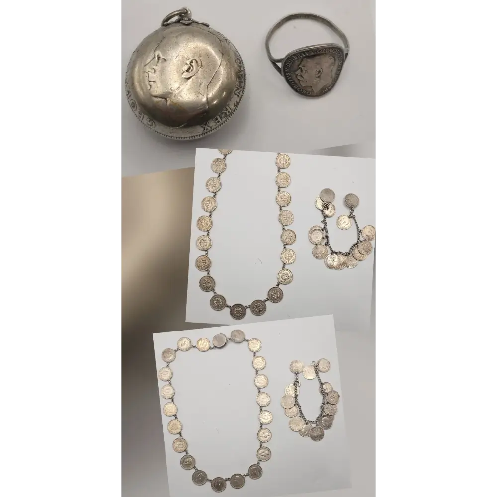 Silver jewelry set including necklaces, a ring, and a pendant on a white surface.
