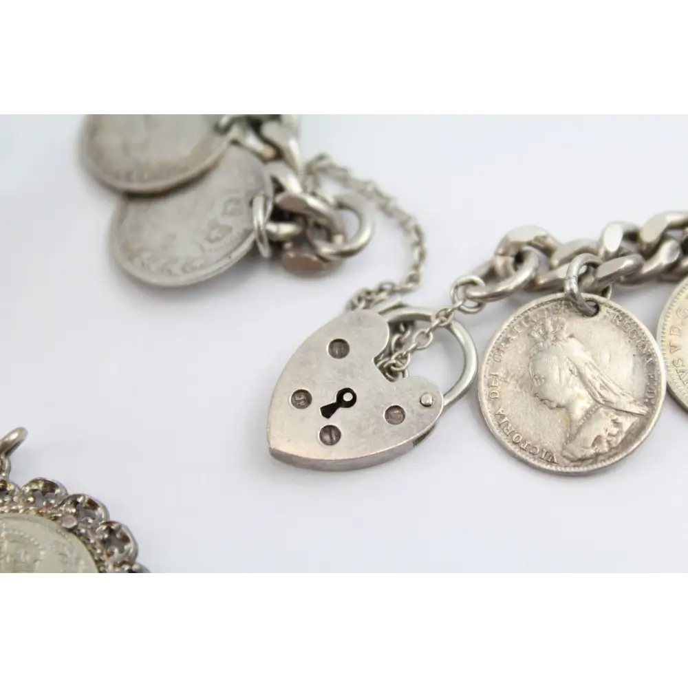 Silver bracelet with various charms including a heart-shaped lock charm