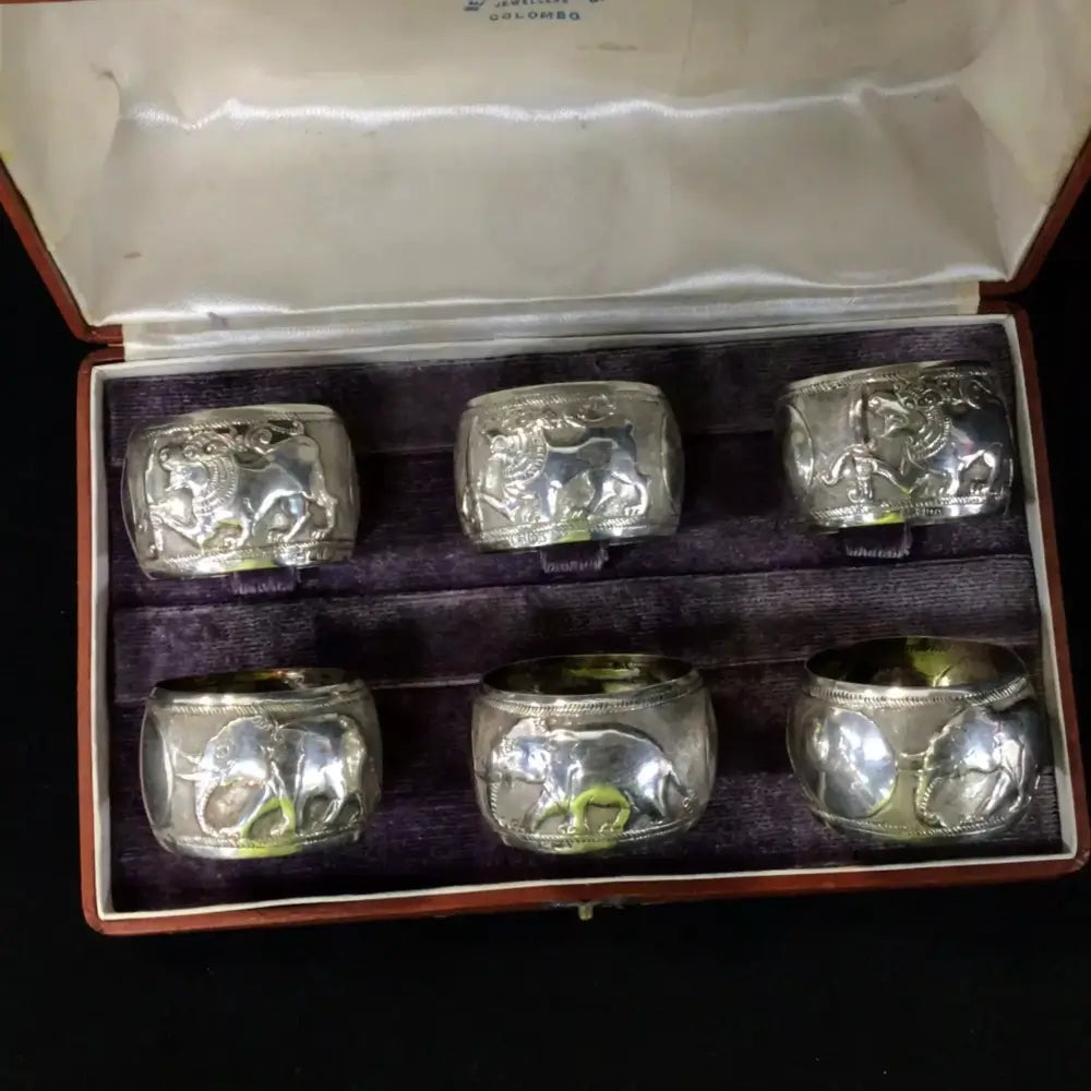 Set of six silver Napkin Rings with engraved designs in a box