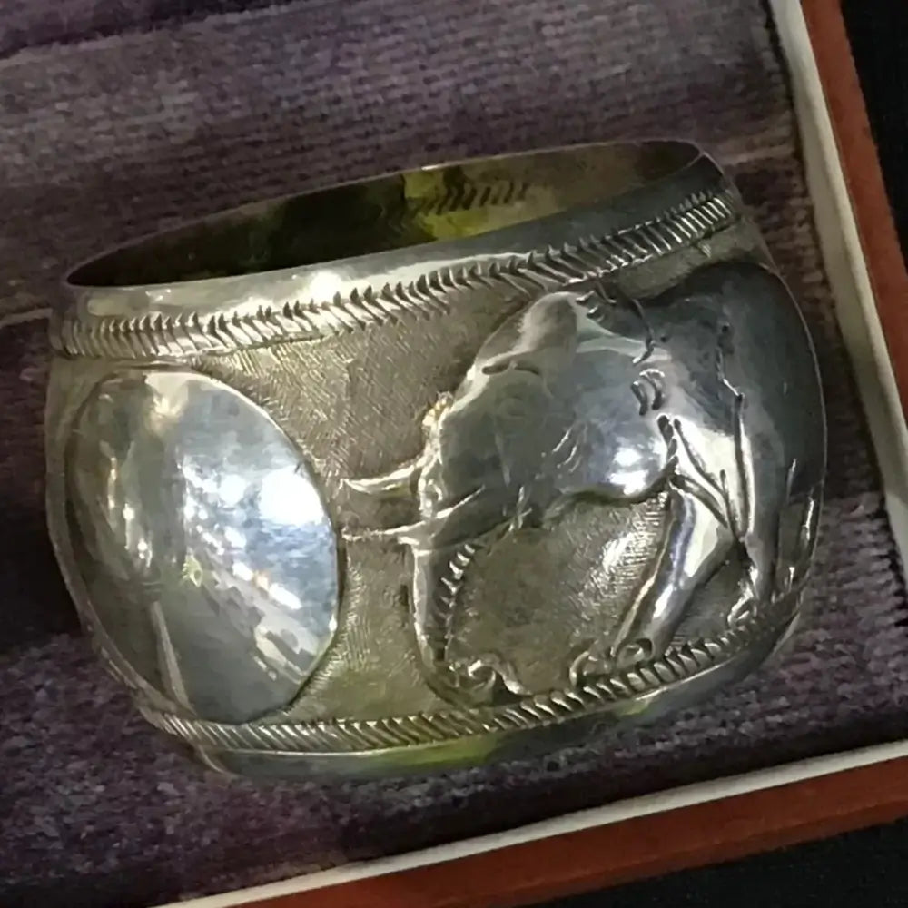 Silver ring with engraved design on a textured surface
