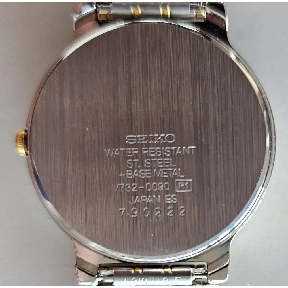 Back view of a Seiko watch with engraved text on a gray background