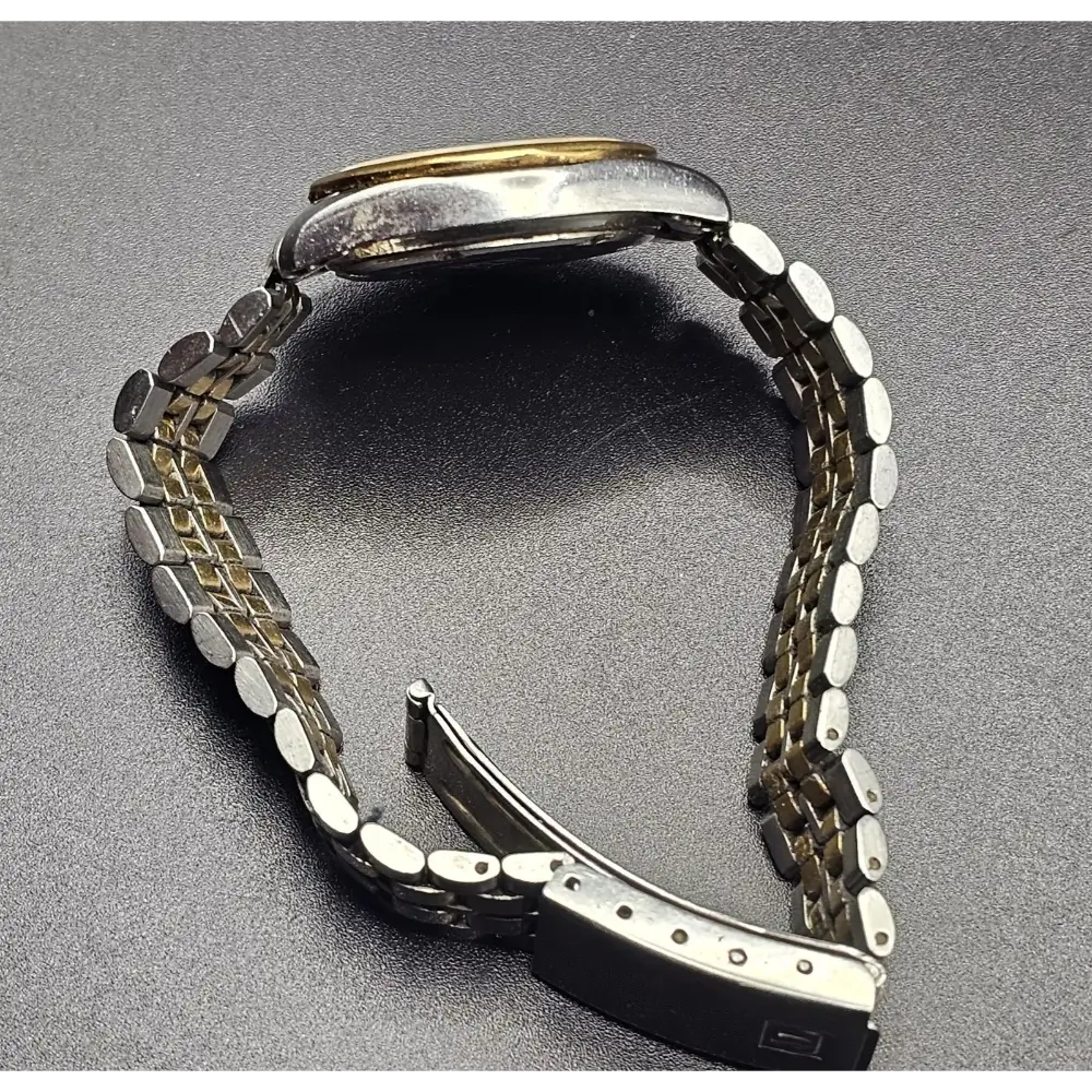 Metallic watch strap on a gray background