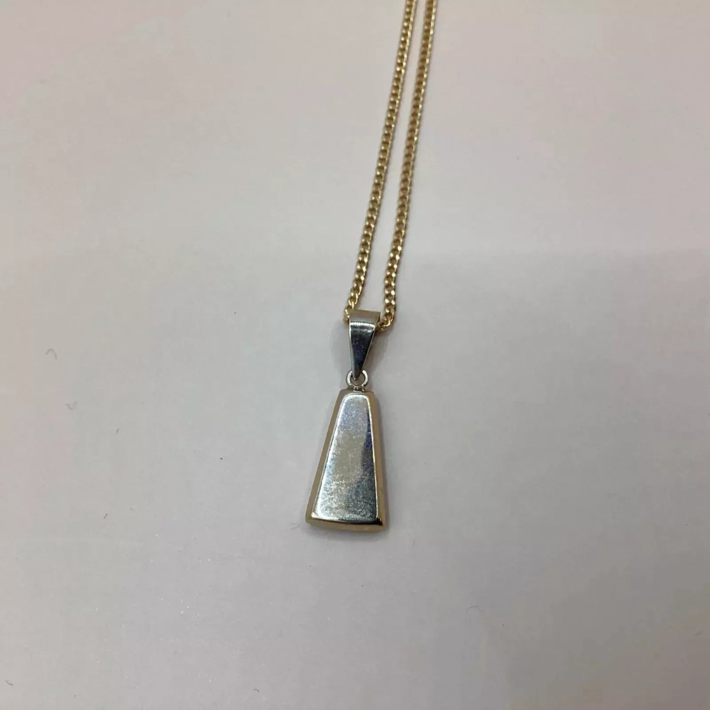 Silver pendant on a gold chain