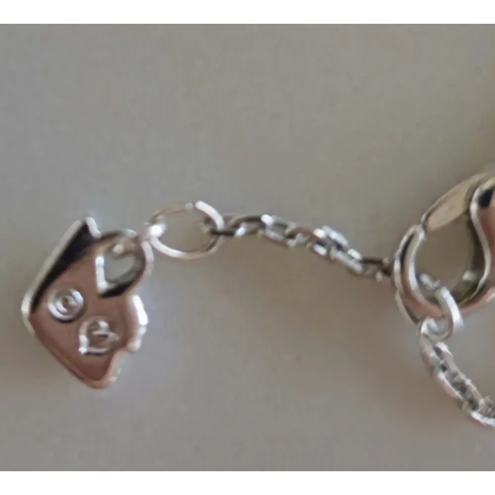 Silver keychain with a small house charm on a light gray background