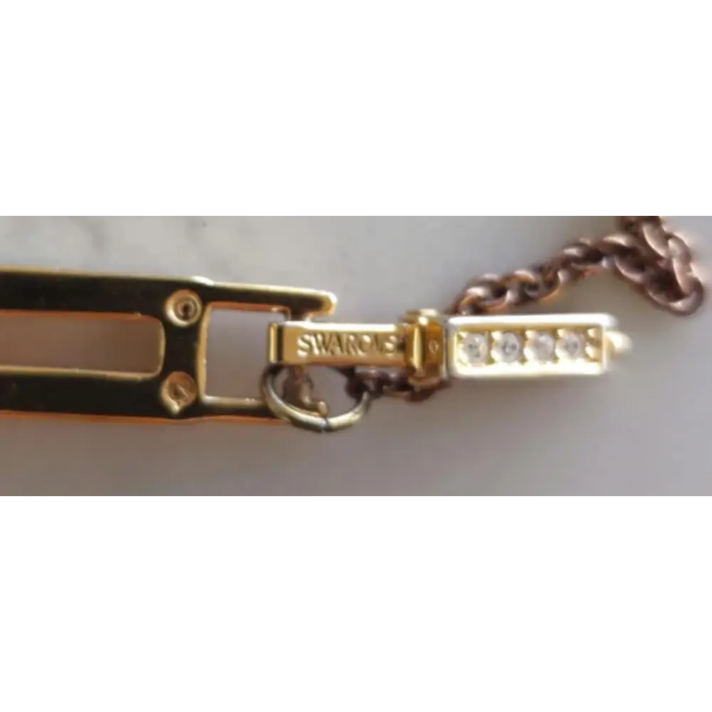 Gold bracelet with diamond accents and 'Swarovski' branding