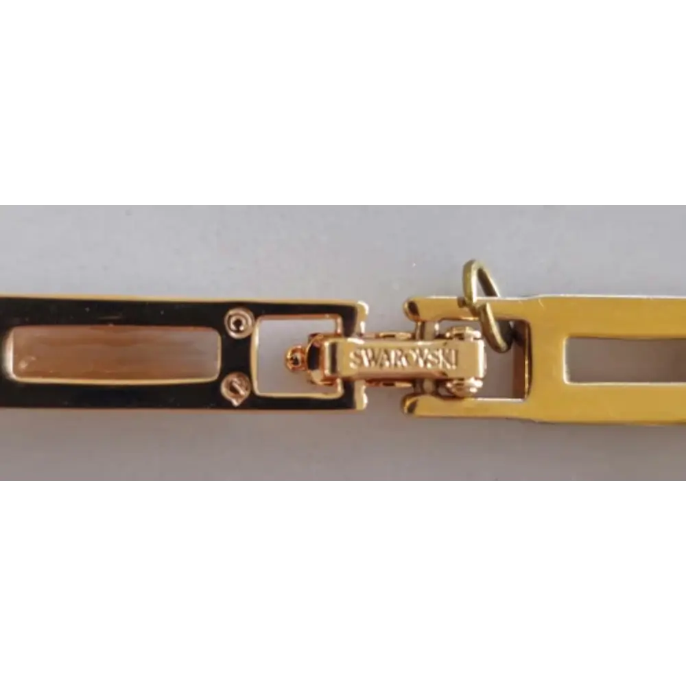 Close-up of a gold bracelet with a Swarovski clasp