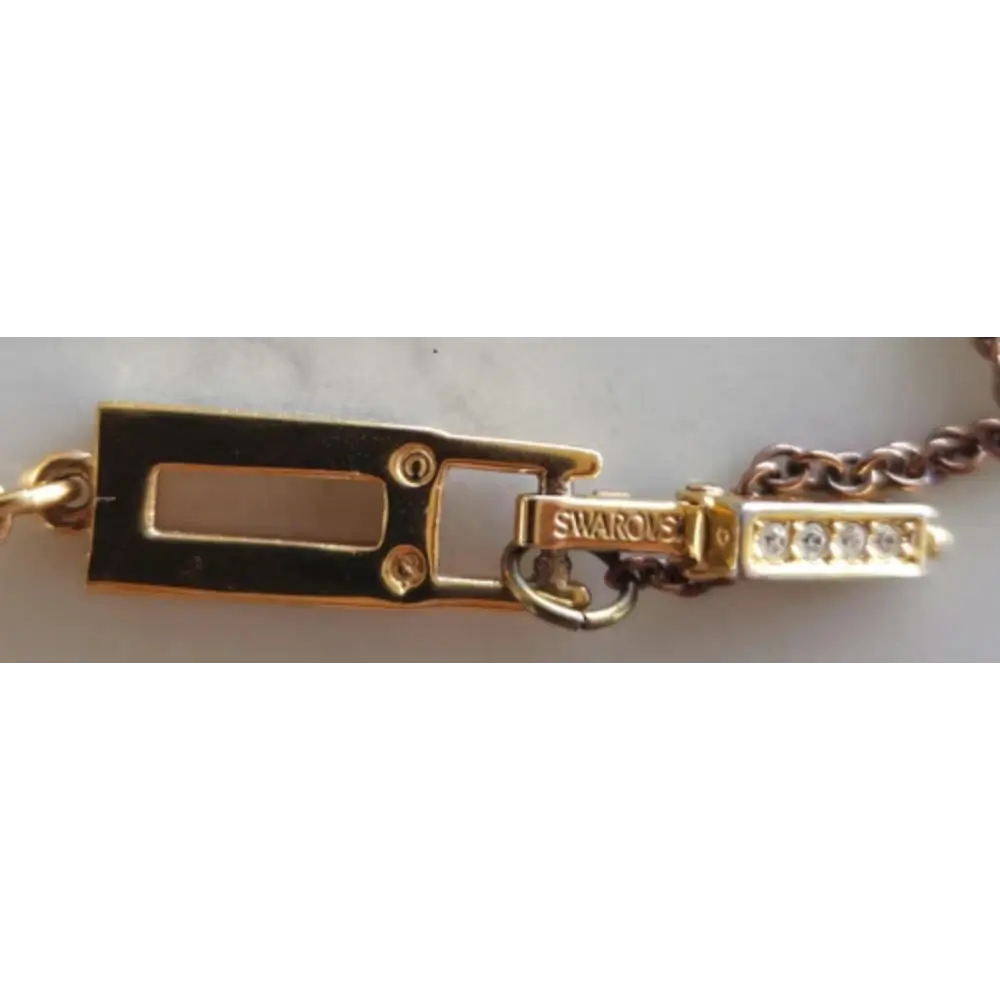 Gold bracelet with a clasp and Swarovski logo