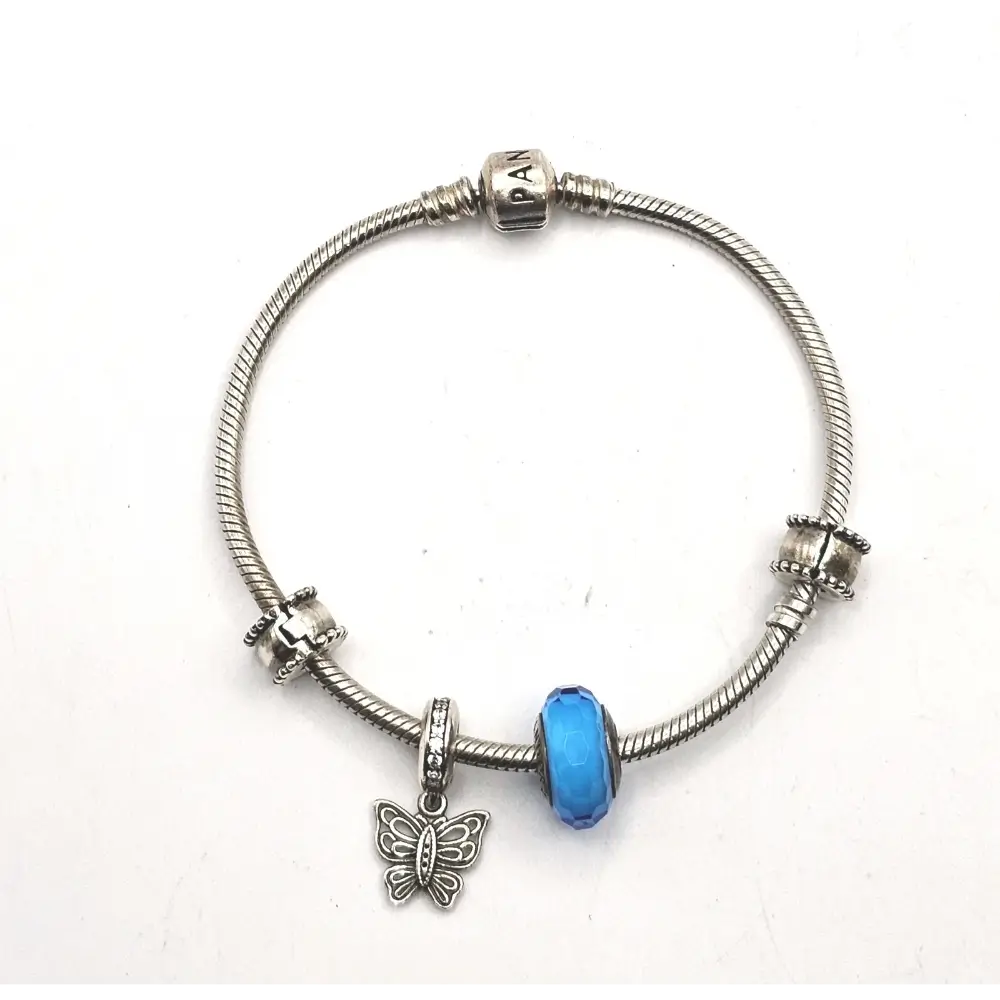 Silver bracelet with a blue bead and butterfly charm on a white background