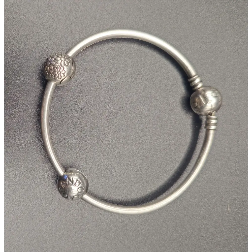 Silver bracelet with decorative beads on a gray background