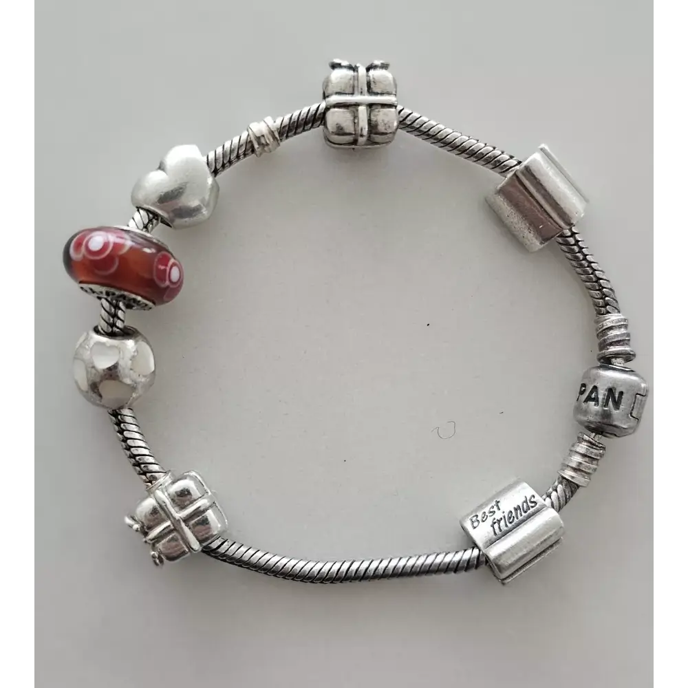 Silver bracelet with various charms on a light gray background