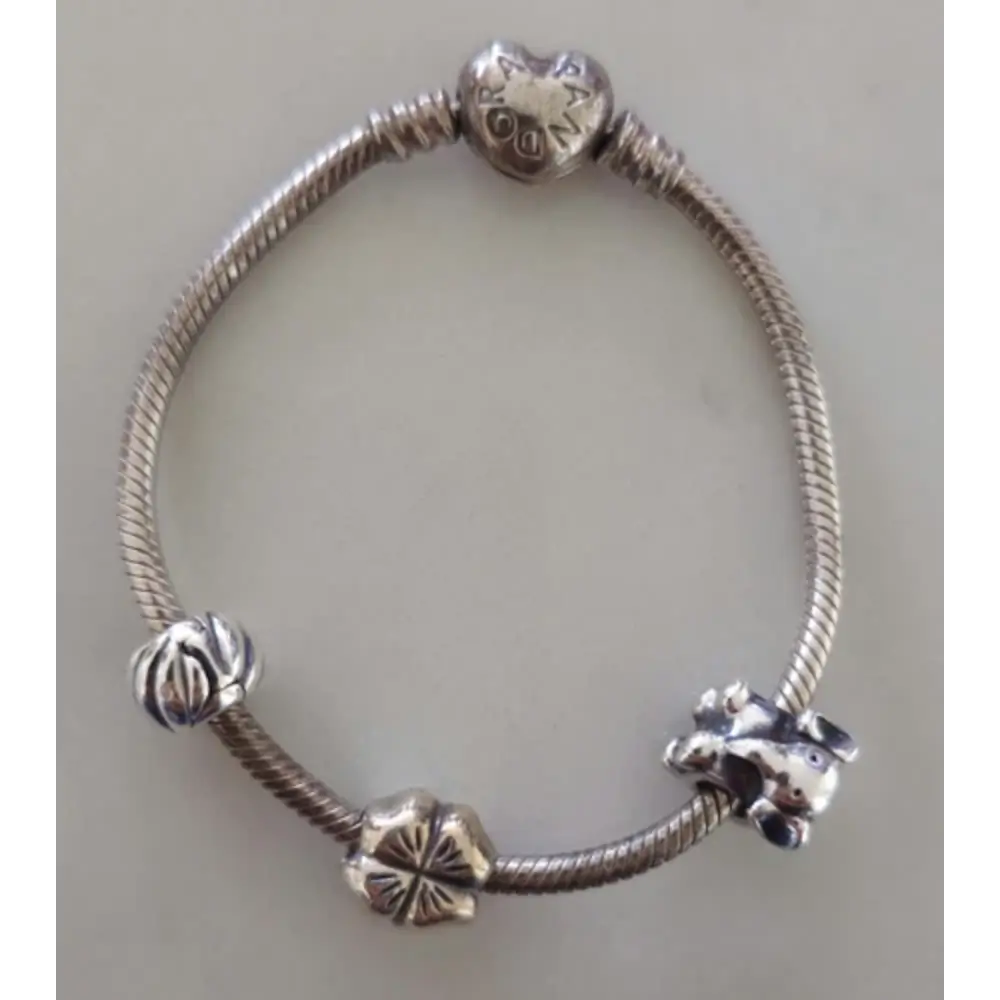 Silver bracelet with various charms on a light gray background