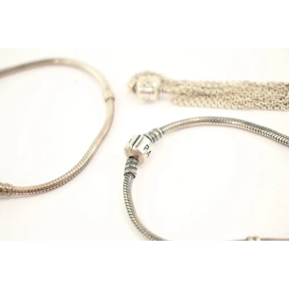 Two silver bracelets with tassels on a white background