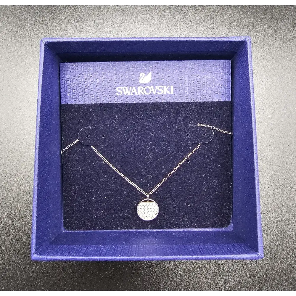 Swarovski necklace in a branded box on a gray background