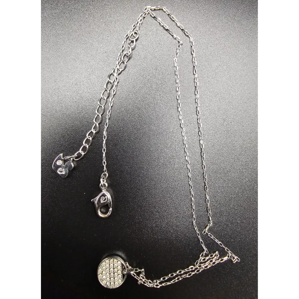 Silver necklace with a pendant on a dark background