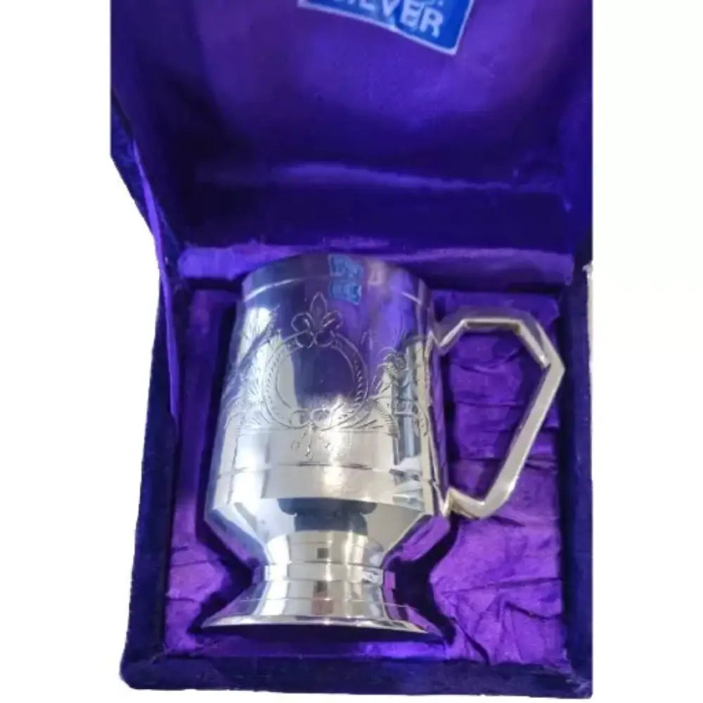 Silver tankard with decorative handle on purple fabric