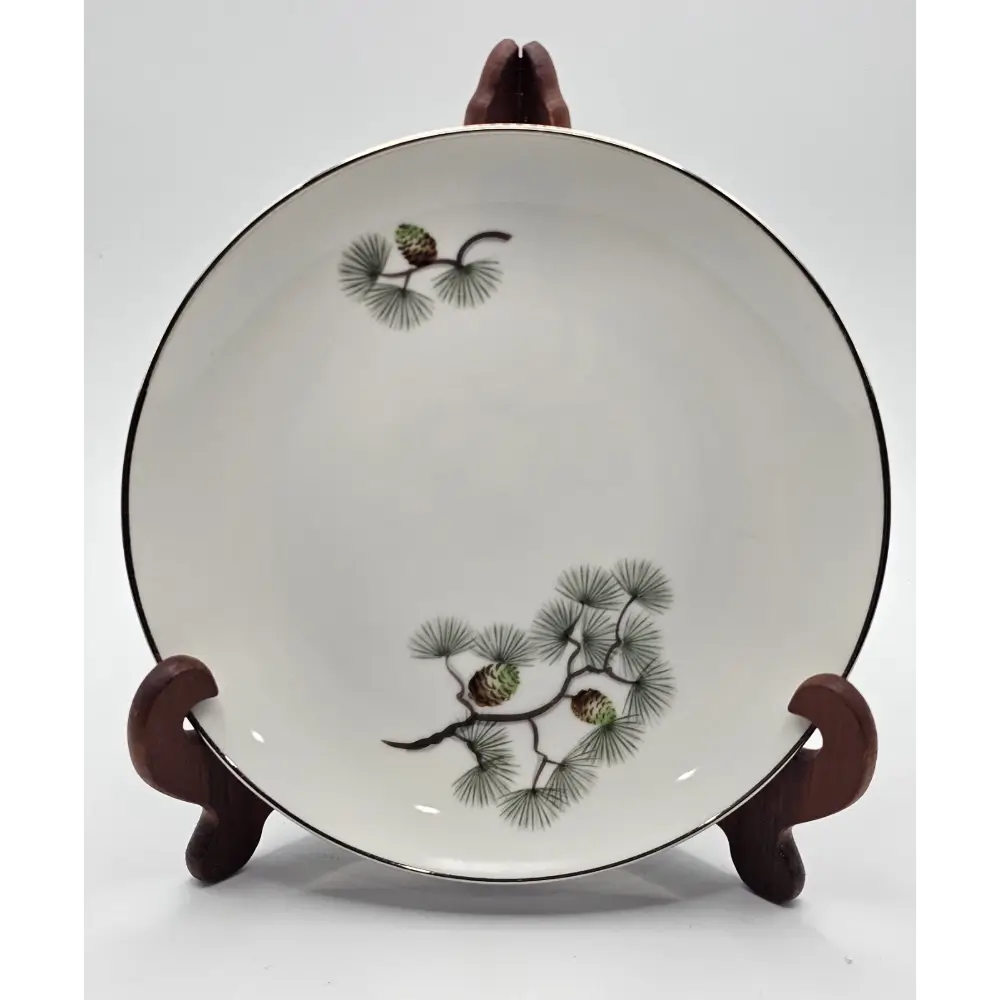 Ceramic plate with pine branch design on a stand