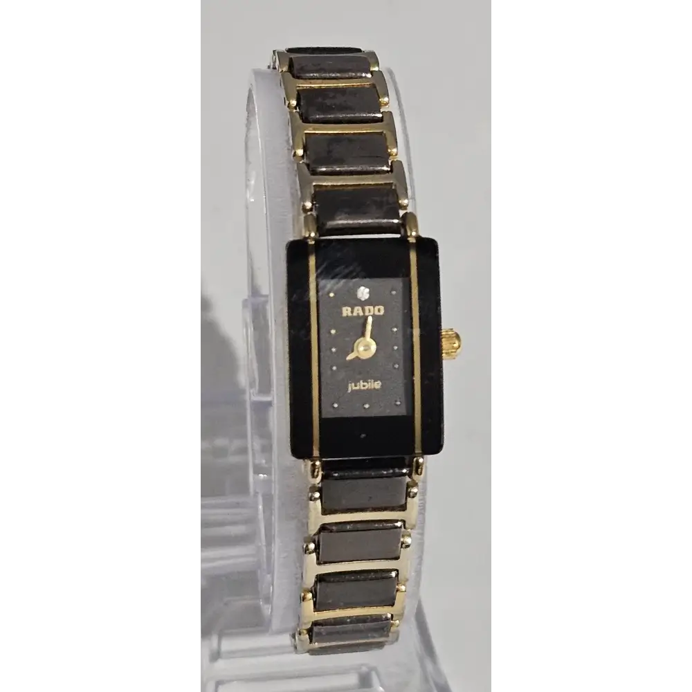 Gold and black watch on a clear stand