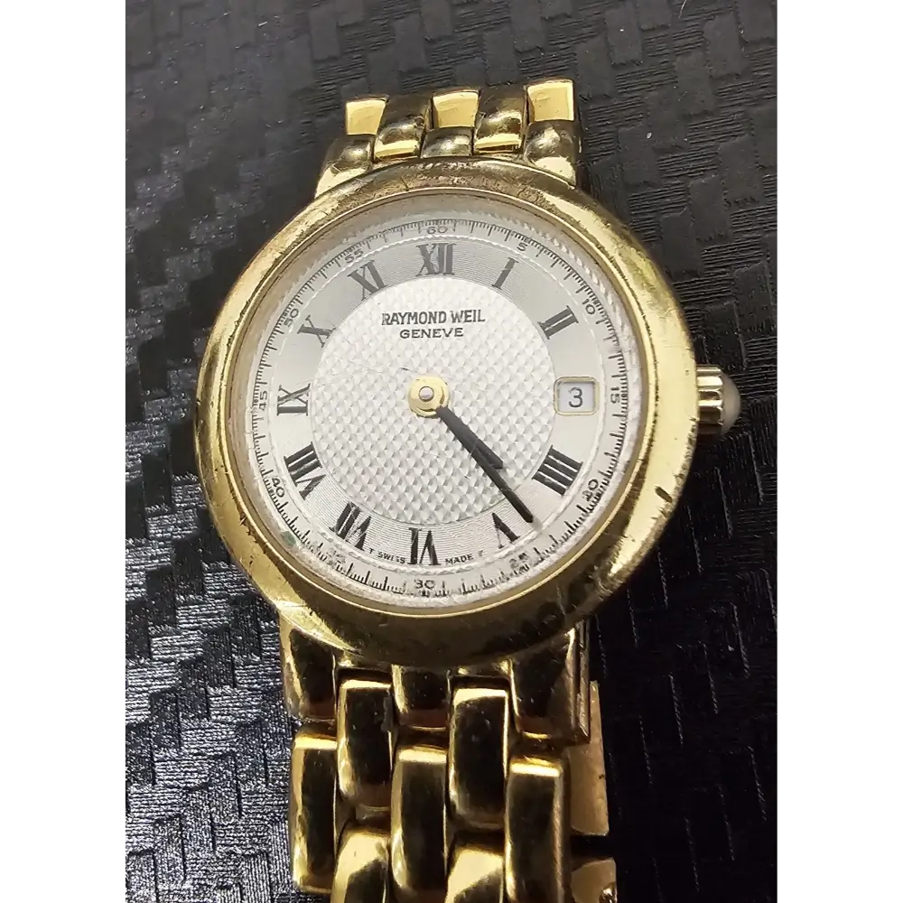 Gold watch with white face and Roman numerals