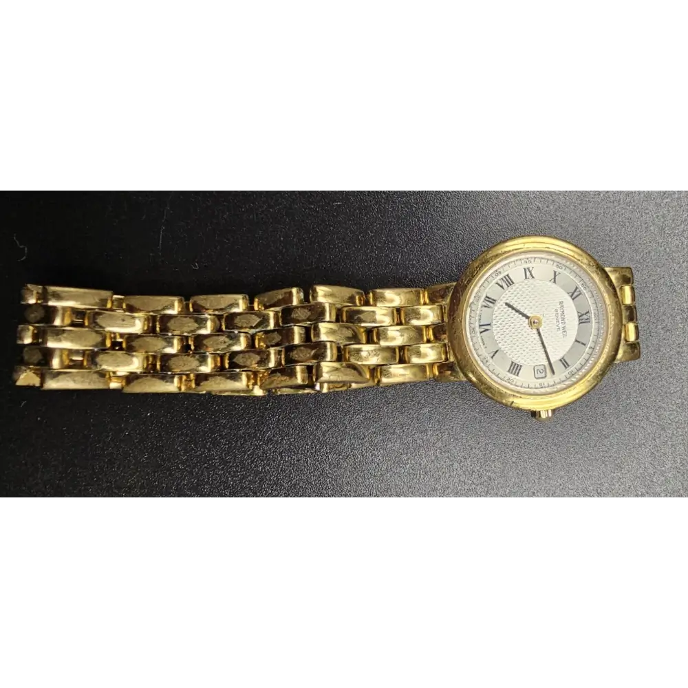 Gold wristwatch with a white face on a black background