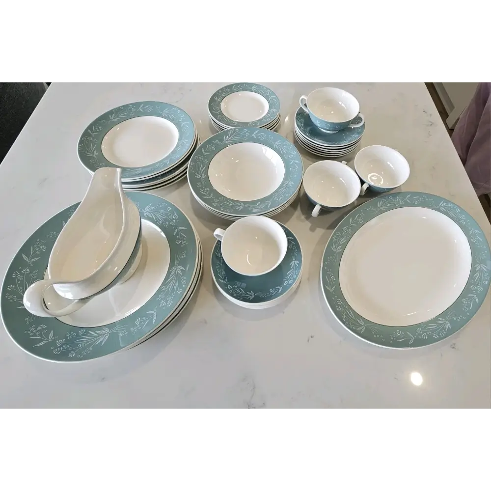 Dinnerware set with green and white pattern on a white surface