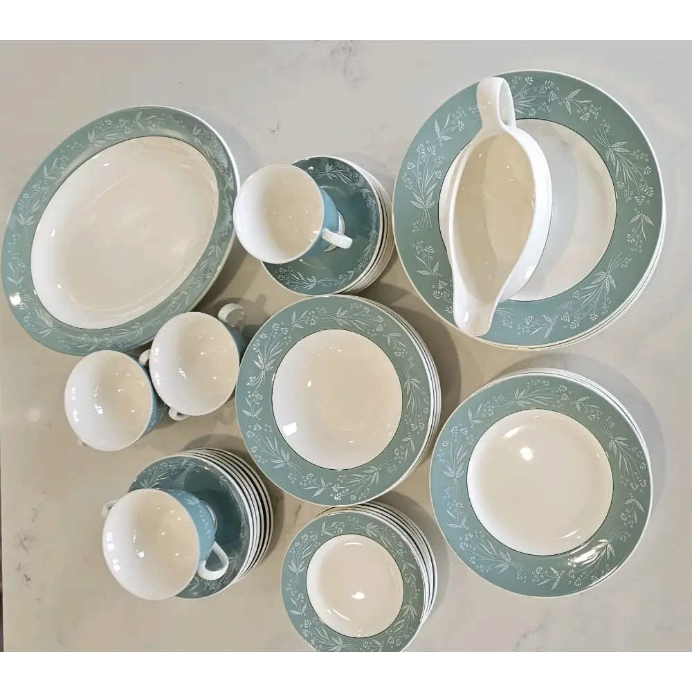 Set of ceramic dishes with green floral patterns on a light gray background