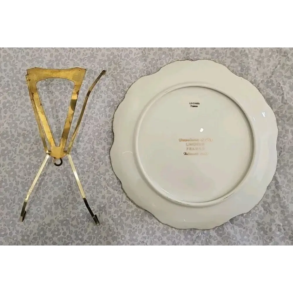 Gold decorative stand next to a white plate with gold text on a patterned surface