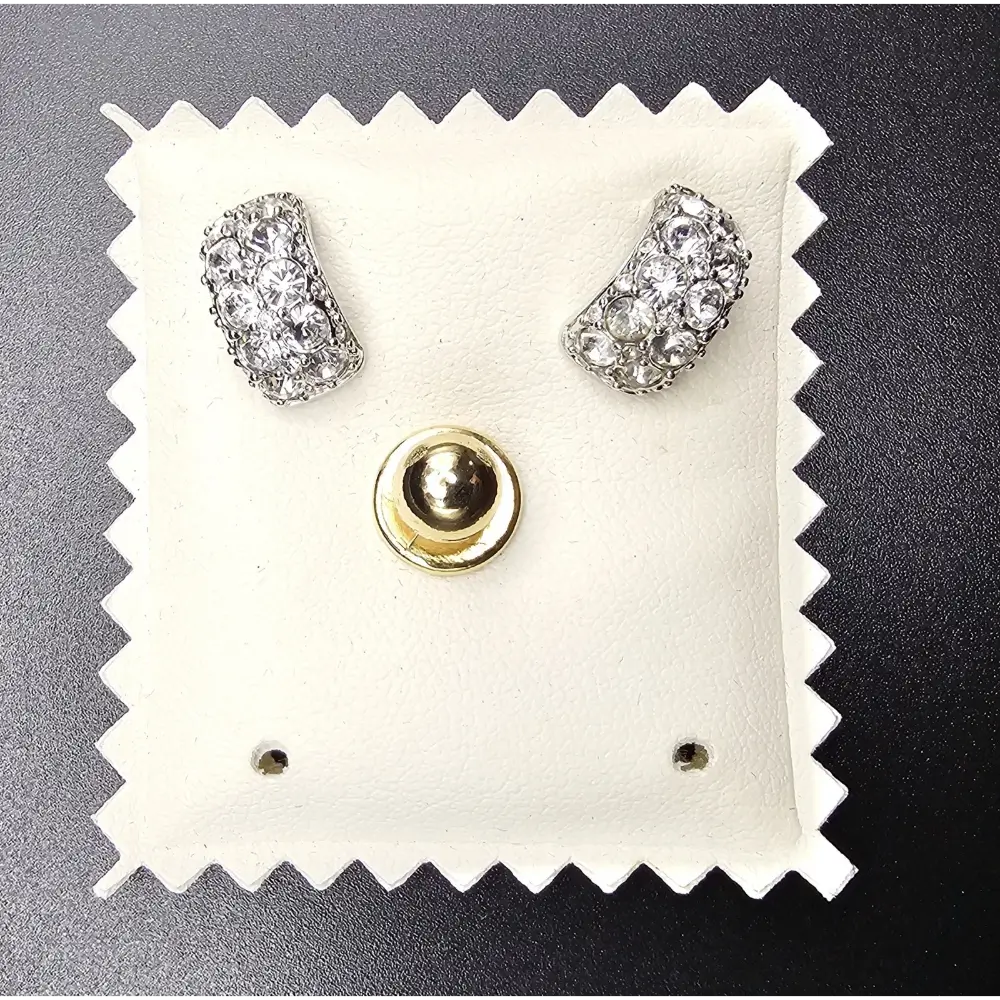 Pair of silver earrings on a white cushion