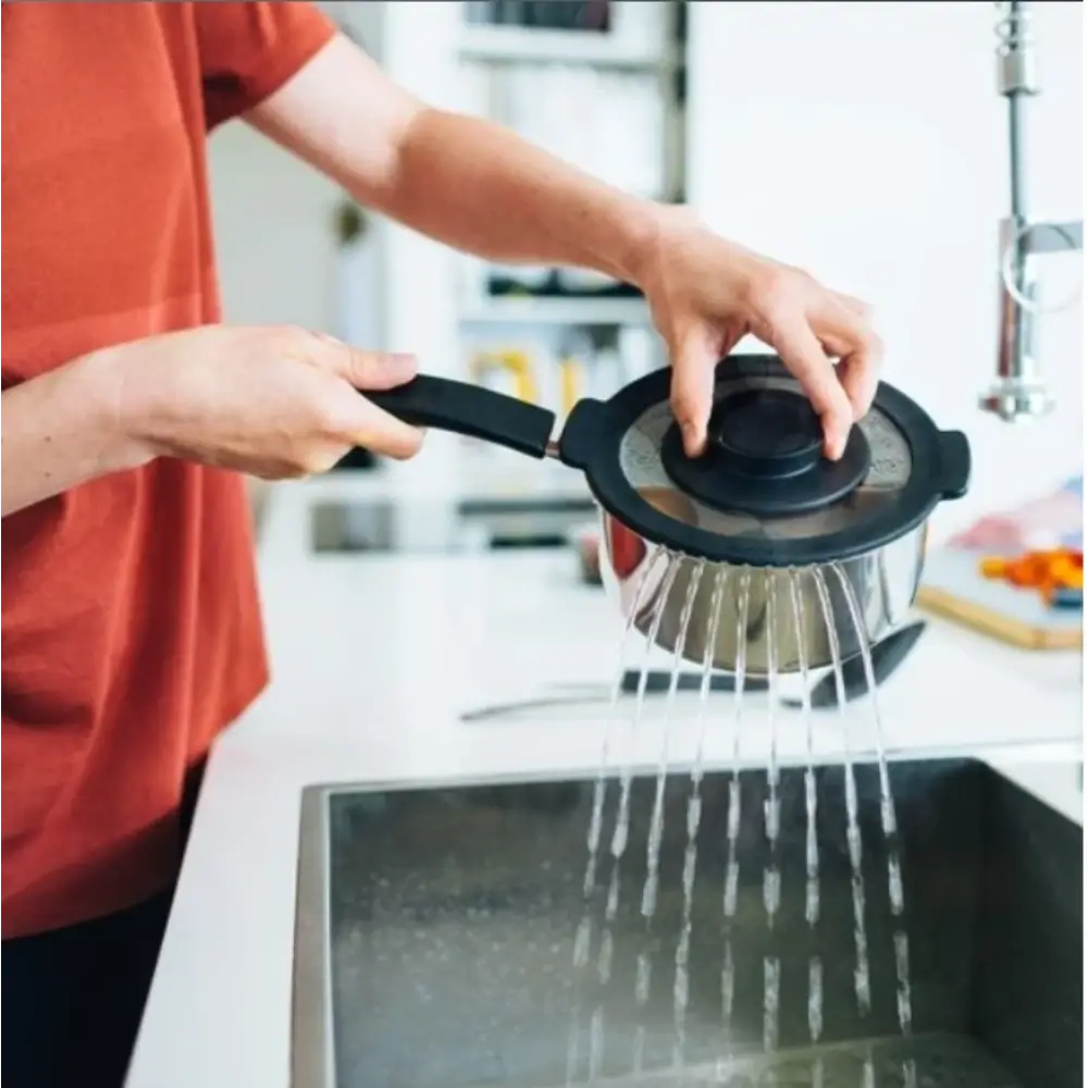 Person using a kitchen strainer over a sink