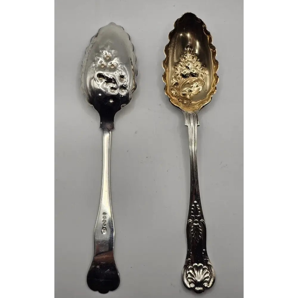 Two silver spoons with intricate designs