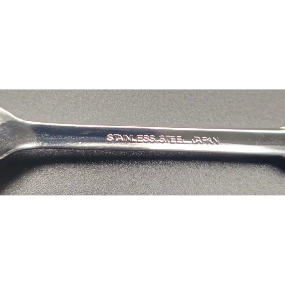 Metal wrench with 'Stainless Steel' engraving on a gray background