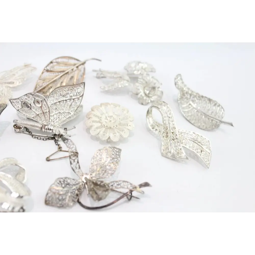 Collection of silver brooches on a white background
