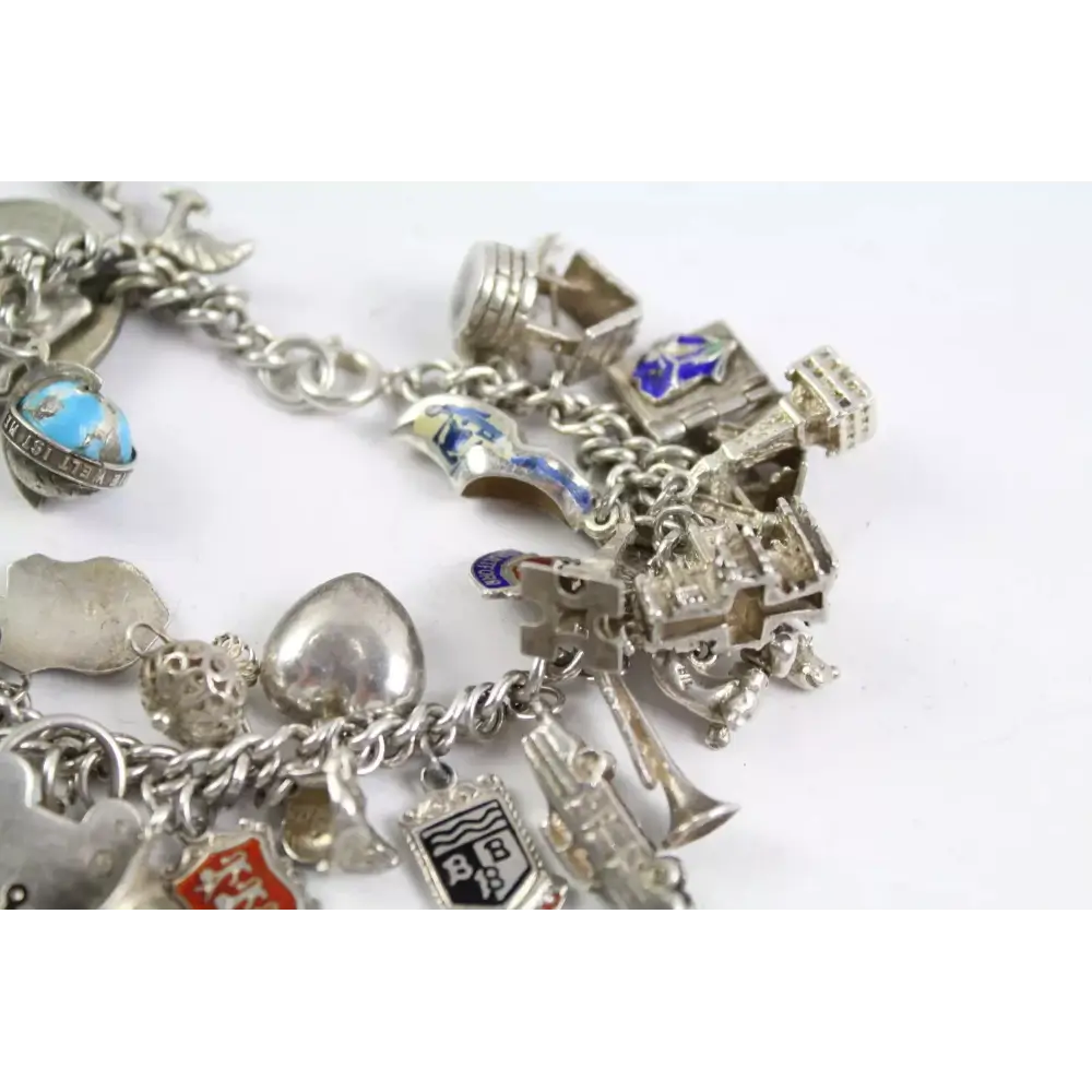 Silver charm bracelet with various charms on a white background