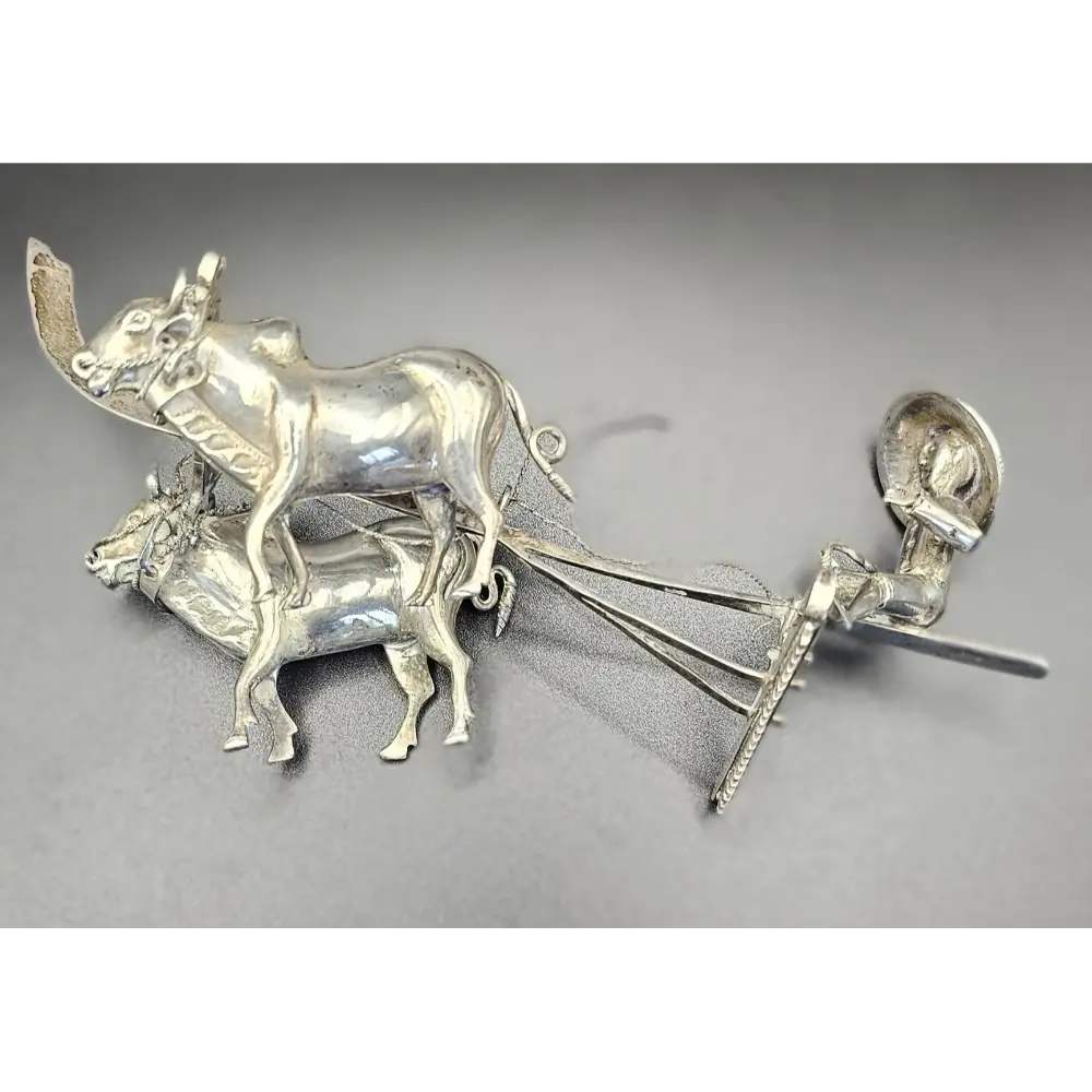 Silver bull and cart figurine