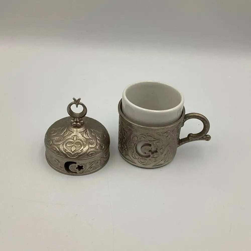 Decorative silver bell and cup on a white background