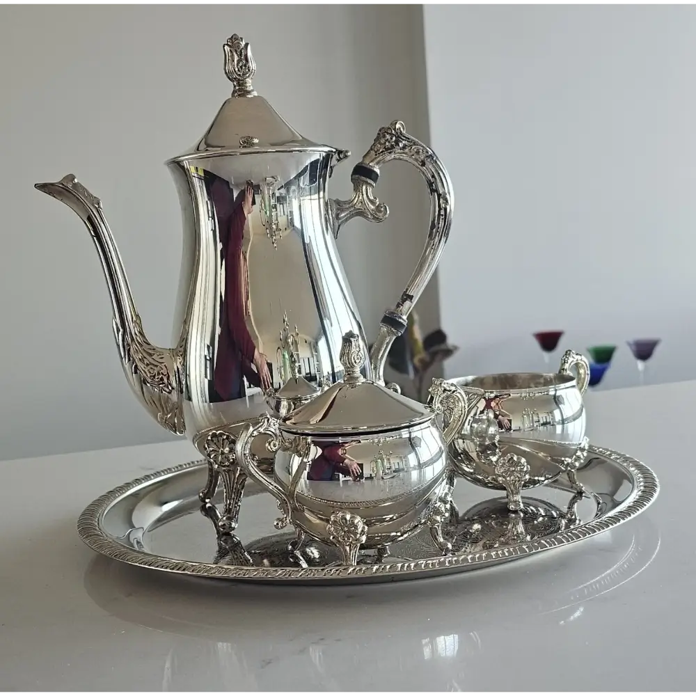 Silver tea set with teapot, sugar bowl, and creamer on a tray
