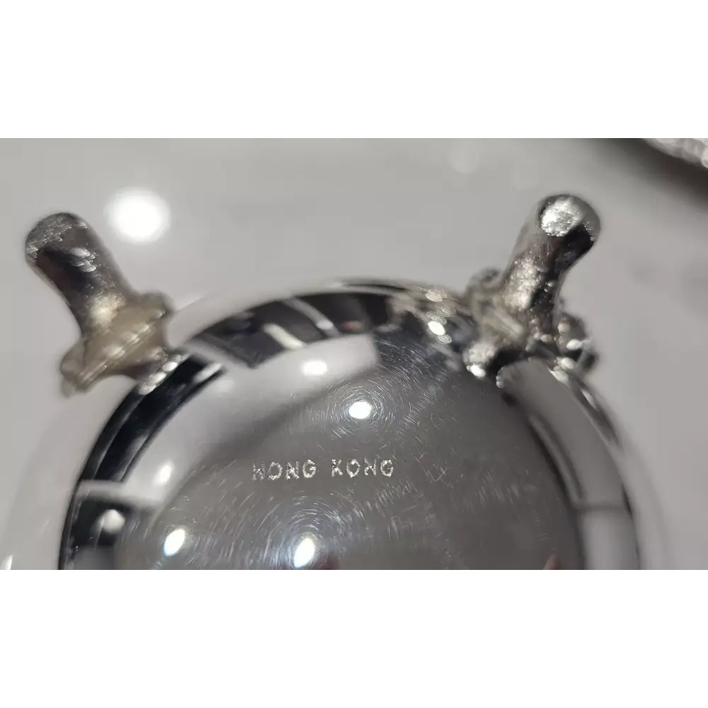Close-up of a metallic object with 'Hong Kong' engraved on it
