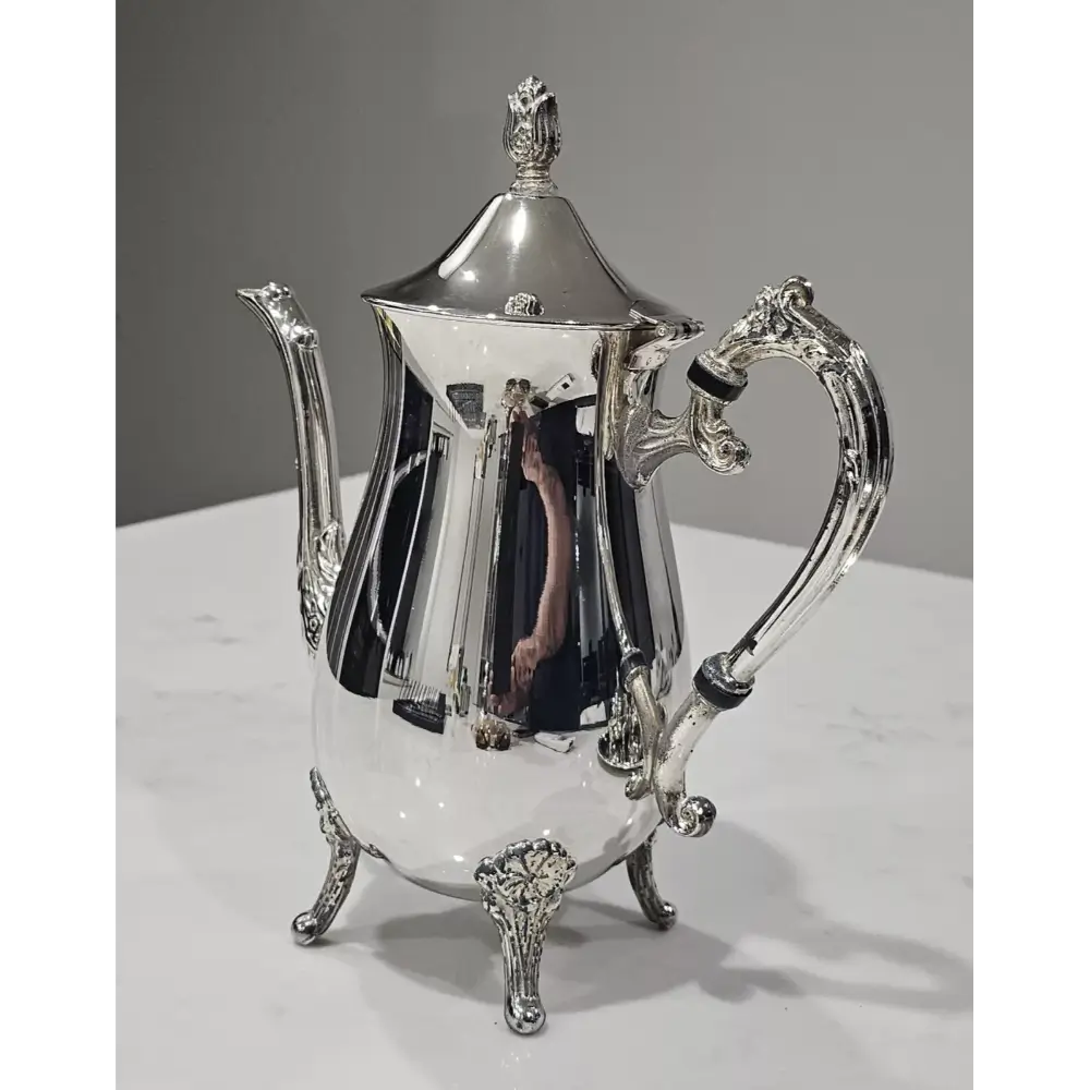 Silver teapot on a white surface