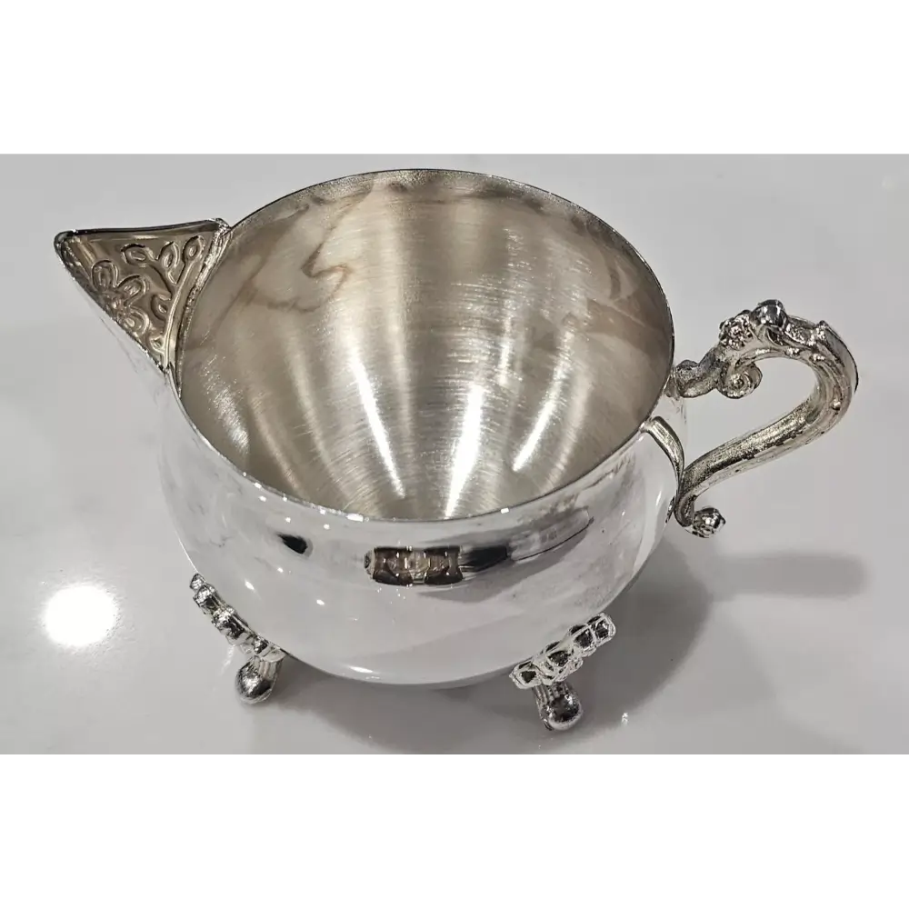Silver creamer with ornate handle