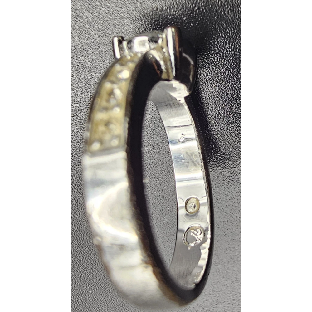Silver ring with engraved design on a textured gray background