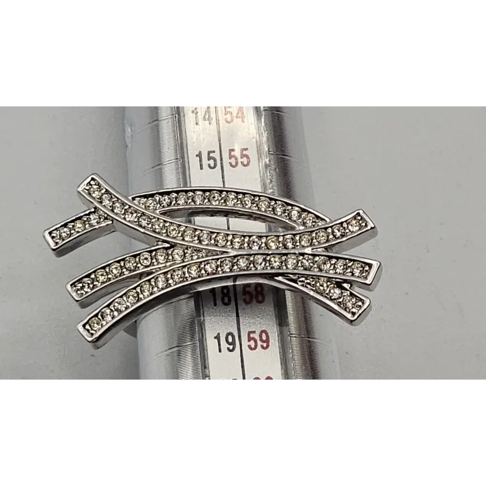 Silver ring with diamond accents on a metal surface