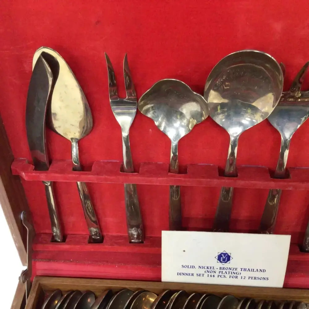 Set of silver cutlery in a red case with a label