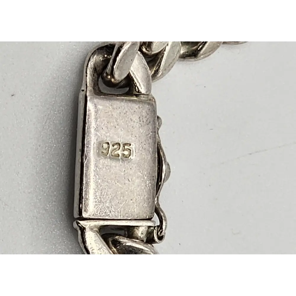 Close-up of a silver bracelet with '925' stamp