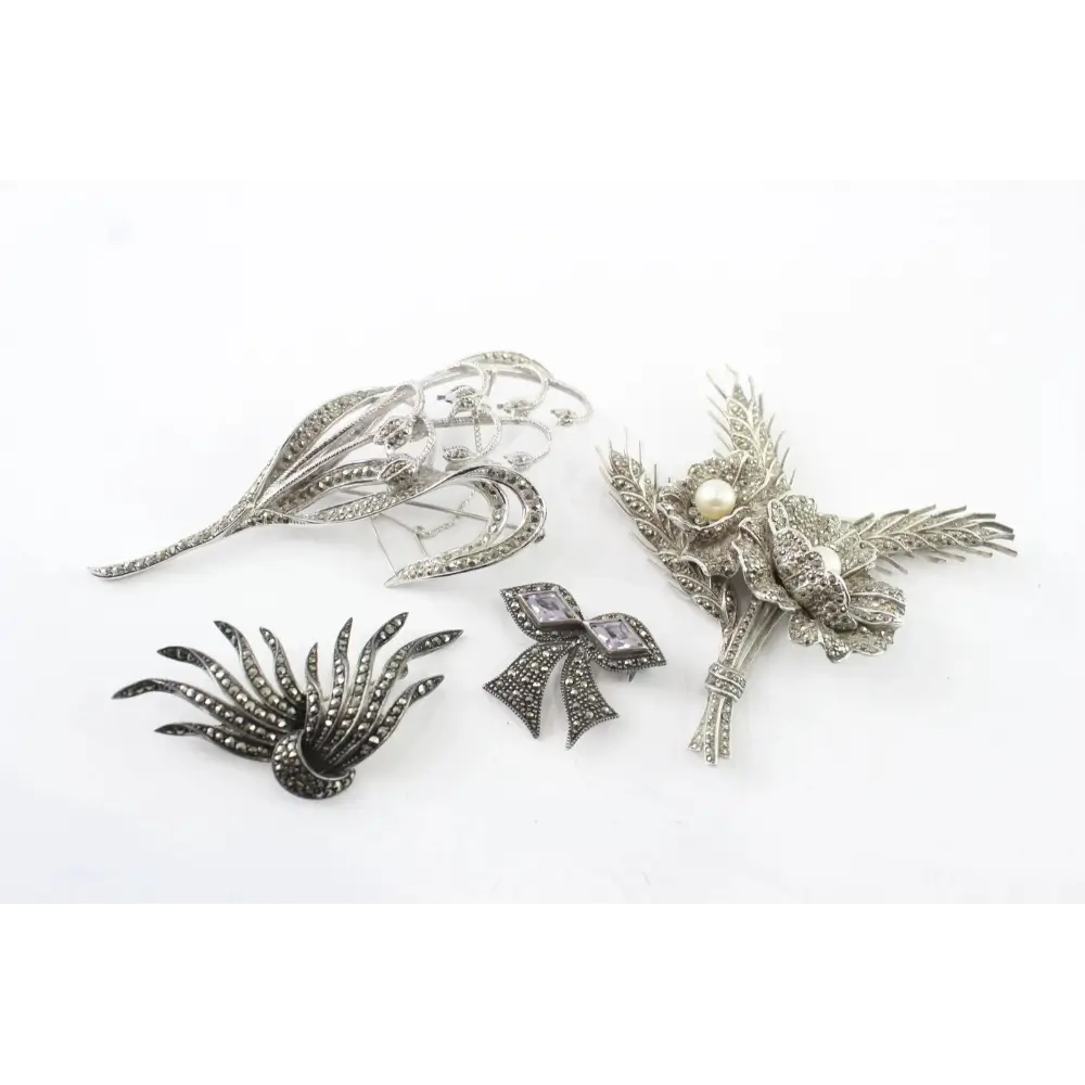 Collection of silver brooches on a white background