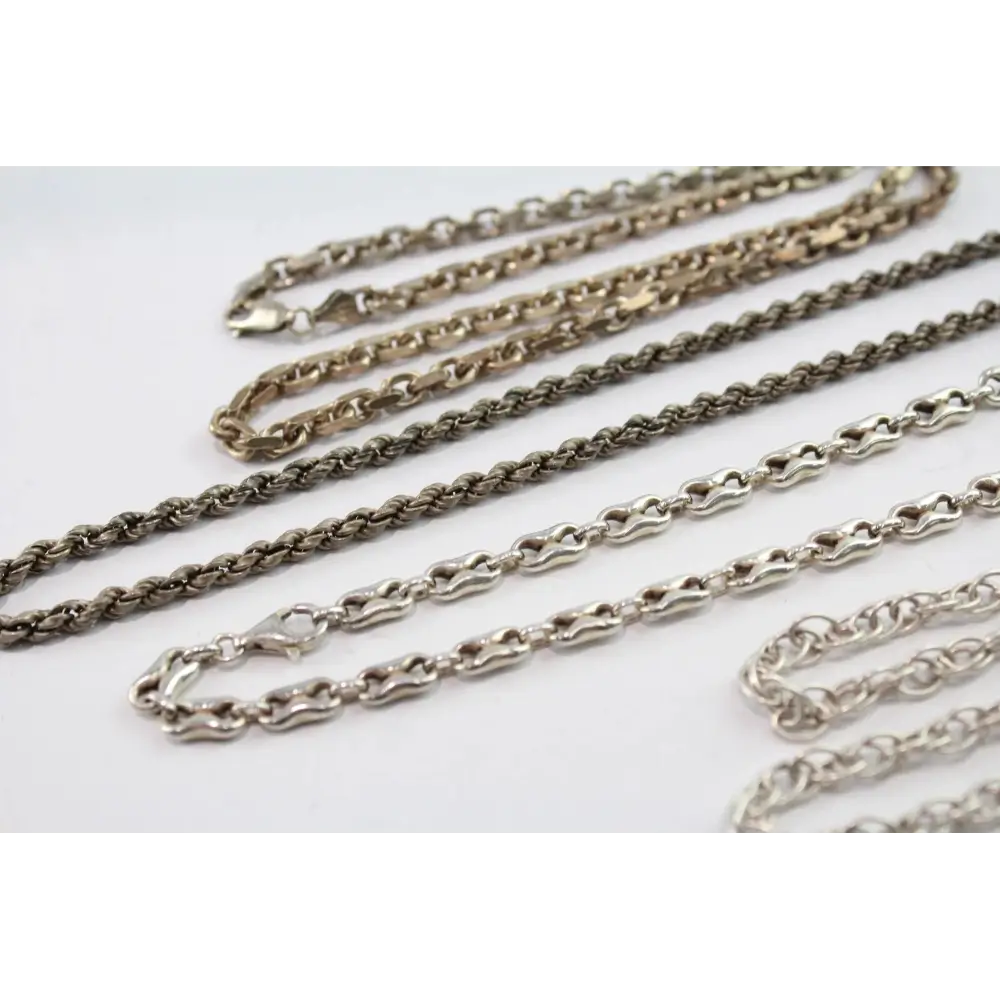 Collection of silver chain necklaces on a white background